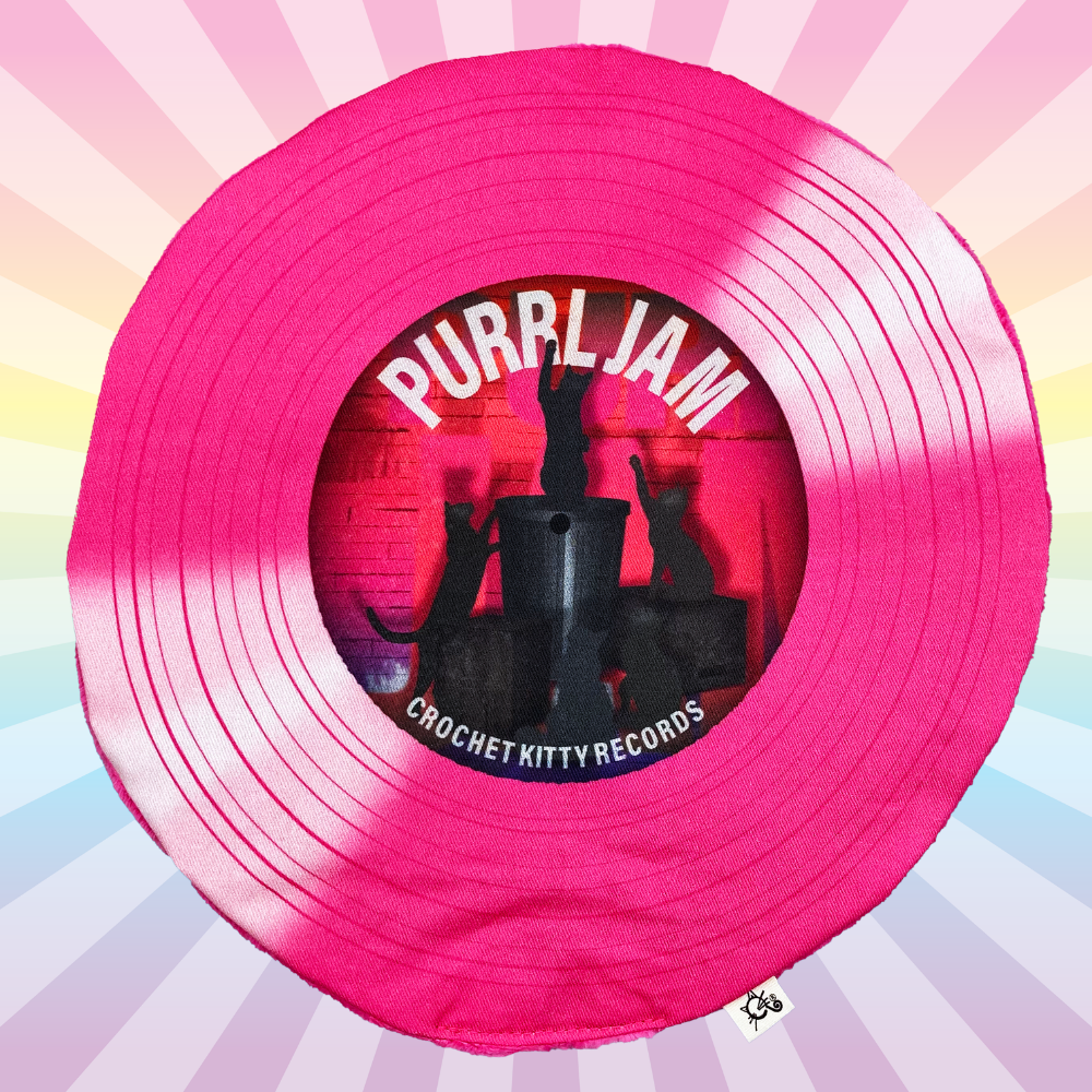 Hot pink Purrl Jam catnip record mat with black cat silhouettes on a pastel rainbow sunburst background.