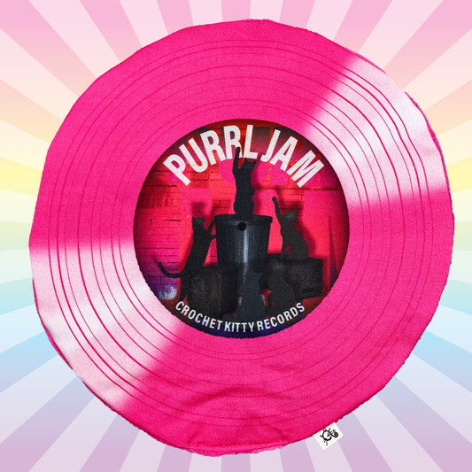 Hot pink Purrl Jam catnip record mat with black cat silhouettes on a pastel rainbow sunburst background.