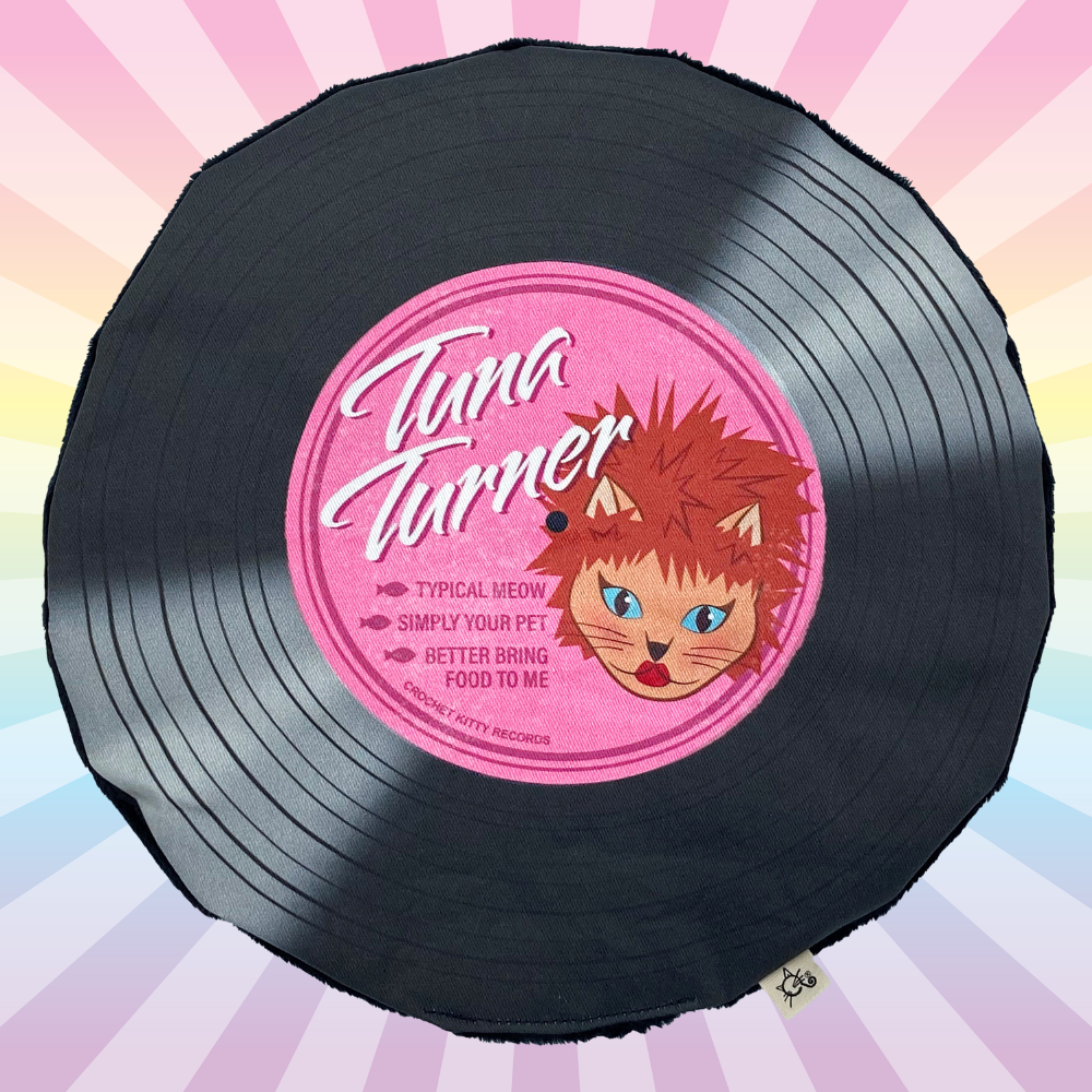 Black Tuna Turner catnip record mat with a pink cat illustration label on a pastel rainbow sunburst background.
